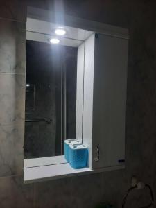Un lavabo de baño con espejo y una cesta azul. en Apartman JELENA M Vrnjačka Banja, en Vrnjačka Banja 8 fotos más
