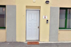 une porte blanche sur un bâtiment jaune avec un panneau sur celui-ci dans l'établissement A San Lazzaro Rooms, à San Lazzaro di Savena