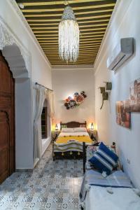 een slaapkamer met een bed en een kroonluchter bij Riad bel kaid fes in Fès