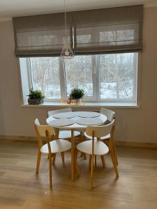 ein Esszimmer mit einem Tisch, Stühlen und einem Fenster in der Unterkunft Roja Lux Apartment in Roja