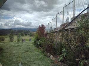 una valla al lado de un campo en Lujosa Casa Quinta en Naturaleza Andina, en Iza