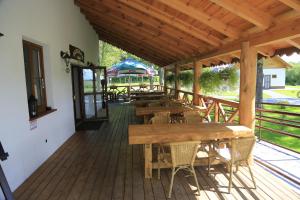 a wooden deck with tables and chairs on it at Pensjonat Bajdarka in Suraż