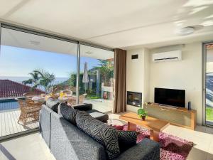 a living room with a couch and a television at Casa Inês by LovelyStay in Arco da Calheta