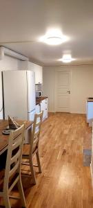 uma cozinha com uma mesa e um frigorífico branco em Aurora rooms for rent nr3 we are doing Northen Lights trip, Reaindear trip and Sommaroy Fjord trips em Tromsø