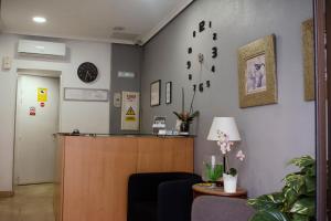 a waiting room with a reception desk and a clock on the wall at Hostal Ártico in Madrid