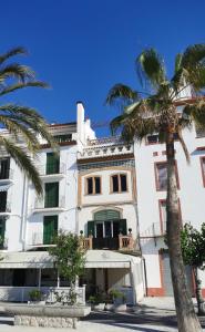 a building with palm trees in front of it at Apartaments Mare Nostrum in Sitges