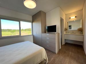 1 dormitorio con 1 cama, TV y ventana en Casa Sunset - La Candelaria en Candelaria