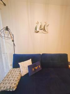 a blue couch with pillows on it in a living room at M&K Apartament Szafirowy - Wyspa Sobieszewska in Gdańsk