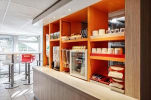 une cuisine avec des armoires orange et un comptoir dans l'établissement Premiere Classe Metz Sud Jouy Aux Arches, à Jouy-aux-Arches