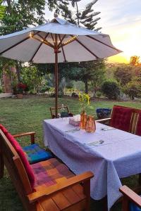 a table with an umbrella and two chairs and a table sidx sidx sidx at Villa Noina Glamping in Ban Nong Takhain