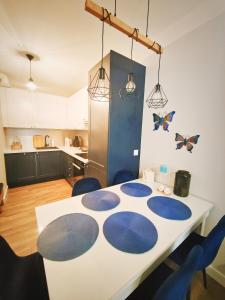 a kitchen with a white table with blue circles on it at M&K Apartament Szafirowy - Wyspa Sobieszewska in Gdańsk