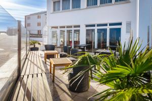 a patio with tables and plants and a building at Hotel auf den Hummerklippen in Helgoland
