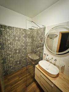 a bathroom with a sink and a glass shower at M&K Apartament Szafirowy - Wyspa Sobieszewska in Gdańsk