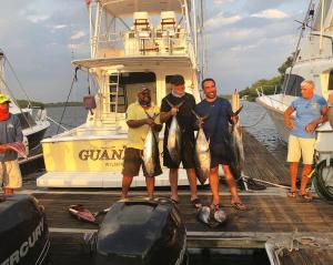 a group of men holding fish on a dock at Casa Sunzal in La Libertad