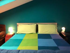 una camera con un letto colorato con due lampade di Appartamento Alcoba a Pontedera