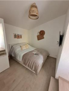 サン・ブルヴァン・レ・パンにあるMaison location Saint Brévin l'Océanの白い部屋のベッドルーム1室(ベッド1台付)