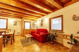 a living room with a red couch and a table at Casa Alpina - Sarre in Aosta