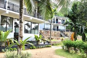 a building with palm trees in front of it at Tea Garden Eco Villas in Morawaka