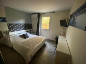 Habitación pequeña con cama y ventana en La Roselière en Saint-Quentin-Fallavier