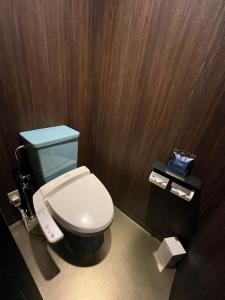 a bathroom with a white toilet and wooden walls at 旭川ホテルユニオン-大人専用 in Asahikawa