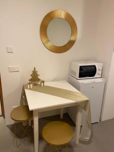 a white table with two chairs and a mirror at Casa Sciliar Stanza gold con parcheggio privato in Völs am Schlern