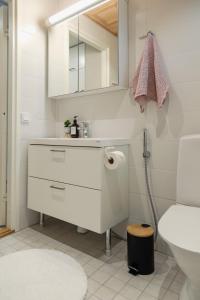 ein weißes Badezimmer mit Waschbecken und Spiegel in der Unterkunft Asunto Kalajoen Golfpuistossa in Kalajoki