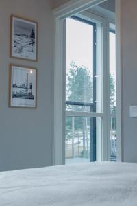 a bedroom with a white bed and a large window at Asunto Kalajoen Golfpuistossa in Kalajoki