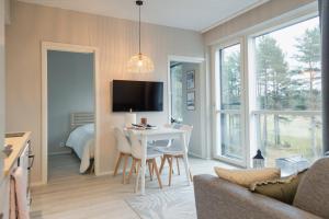 a living room with a table and chairs and a bedroom at Asunto Kalajoen Golfpuistossa in Kalajoki
