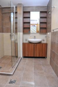 een badkamer met een wastafel en een douche bij APARTMENTS FOKA & SPA - 600m from Gondola ski lift in Kopaonik