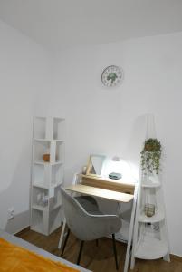a white desk with a chair next to a shelf at NaturaApart bezpłatny parking in Ostrołęka