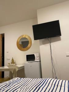 een slaapkamer met een bed en een flatscreen-tv aan de muur bij Casa Sciliar Stanza privata gold in Fiè