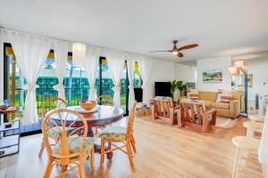 a dining room and living room with a table and chairs at Kauai Beach Villas E5 in Lihue