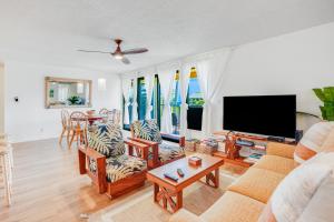 sala de estar con sofá y TV de pantalla plana en Kauai Beach Villas E5, en Lihue