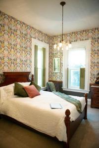 MercerにあるThe Big Brickhouseの花柄の壁紙を用いたベッドルーム1室(大型ベッド1台付)