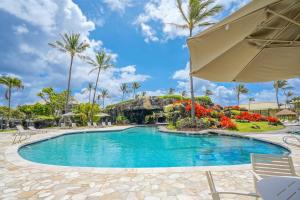 una piscina en un complejo con palmeras en Kauai Beach Villas E5, en Lihue