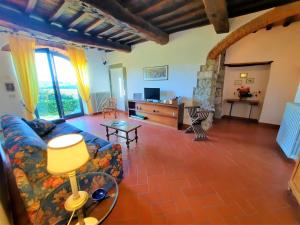 a living room with a couch and a tv at Agriturismo I Ceppi in San Casciano in Val di Pesa