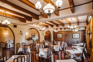 a dining room with tables and chairs and a chandelier at Hotel Melillanca in Valdivia
