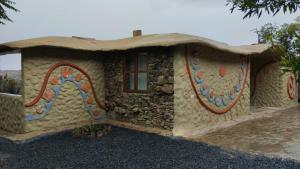 a house with a painting on the side of it at Paraiso de Arcilla - Suite & Glamping in Ráquira