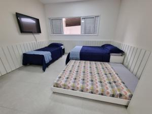 - une chambre avec 2 lits et une télévision à écran plat dans l'établissement Morada da Fé II à 300 m da canção nova Cond. da Fé, à Cachoeira Paulista