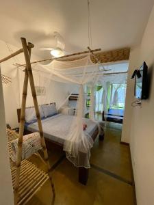 Schlafzimmer mit einem Bett mit Moskitonetz in der Unterkunft Bali Suites Itamambuca in Ubatuba
