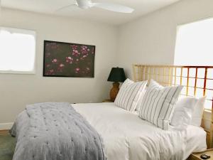 a bedroom with a bed with white sheets and a window at Quiet, convenient & Modern Haven in Gainesville