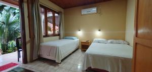 a bedroom with two beds and a window at Hospedaje Jose Gorgues in Puerto Iguazú