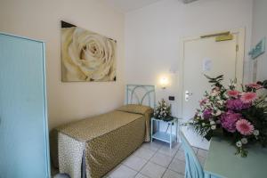 a small room with a bed and flowers in it at Hotel Riviera Blu in Tirrenia