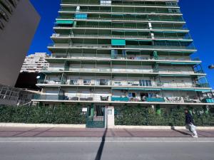 un edificio alto con una persona caminando delante de él en MagicViews by gms apartamentos en Fuengirola