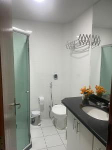 y baño con aseo, lavabo y ducha. en Loft Prainha, en Arraial do Cabo