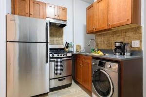 eine Küche mit einem Kühlschrank aus Edelstahl und einem Geschirrspüler in der Unterkunft 1567-1A New 2br PRIME upper East APT W&D in New York