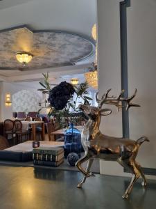 une statue en bronze d'un cerf assis sur une table dans l'établissement Le Mirabeau Resort & Spa, à Zermatt