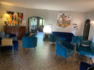 uma sala de estar com cadeiras e mesas azuis em La Roselière em Saint-Quentin-Fallavier