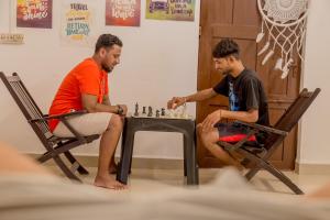 two men sitting in chairs playing a game of chess at BunkNBrew in Palolem