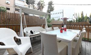 a table and chairs on a patio with a dog laying on it at Josephine's 2Bdrm apt 50M to Bahai gardens in Haifa